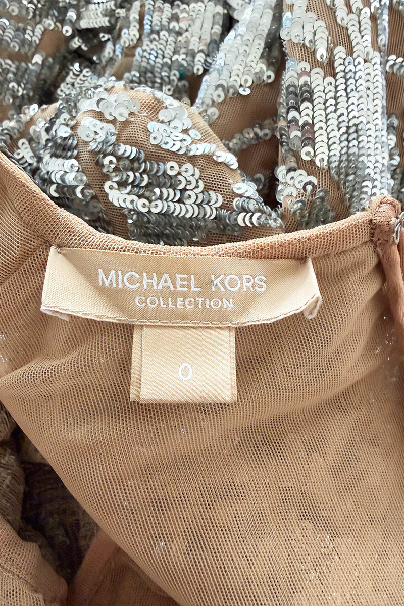 Spring 2018 Michael Kors Runway Look 72 Silver Sequin Dress on Nude Stretch Net w Asymmetrical Hem
